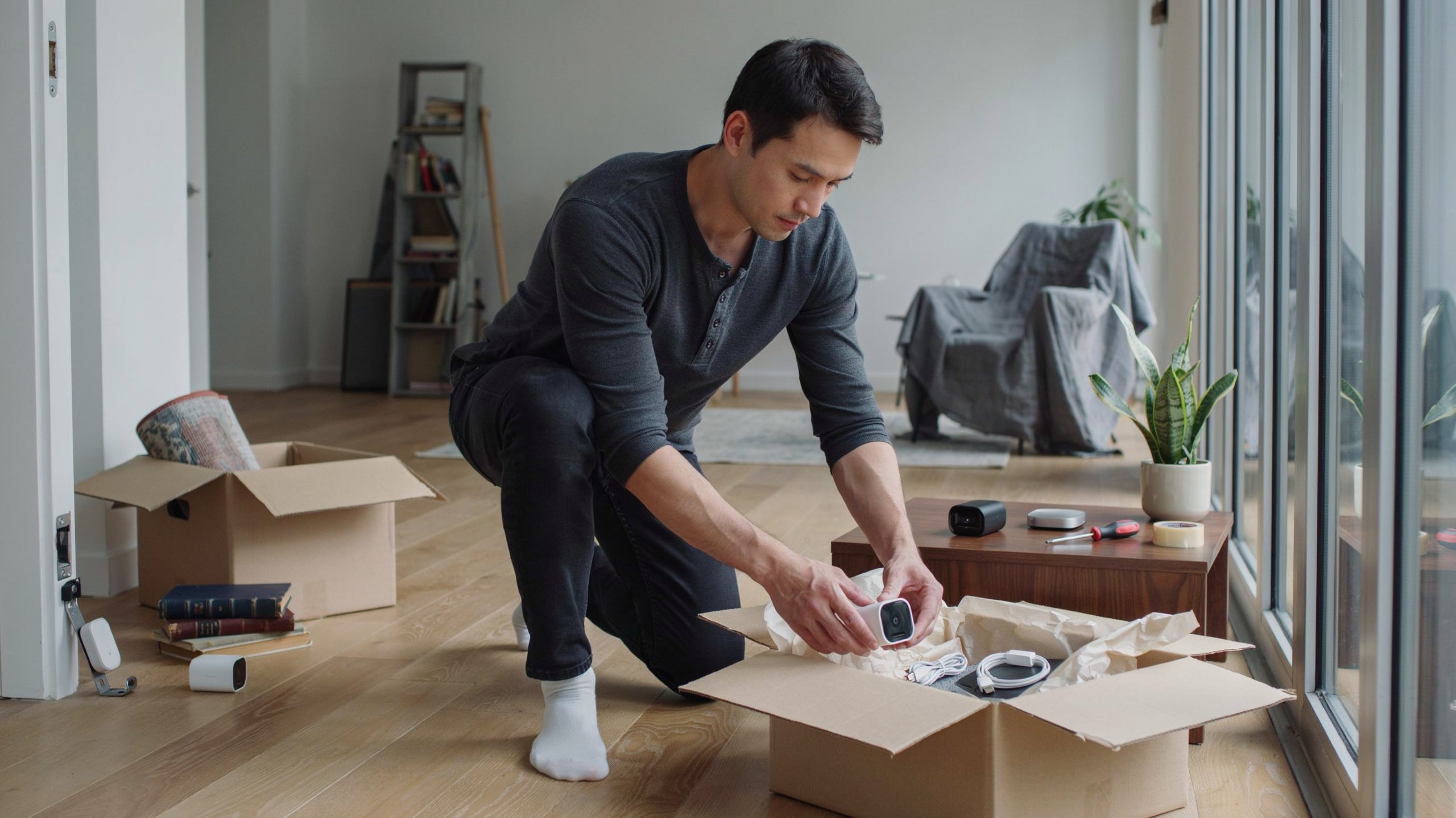 renter unpacking portable smart home security devices when moving into new apartment