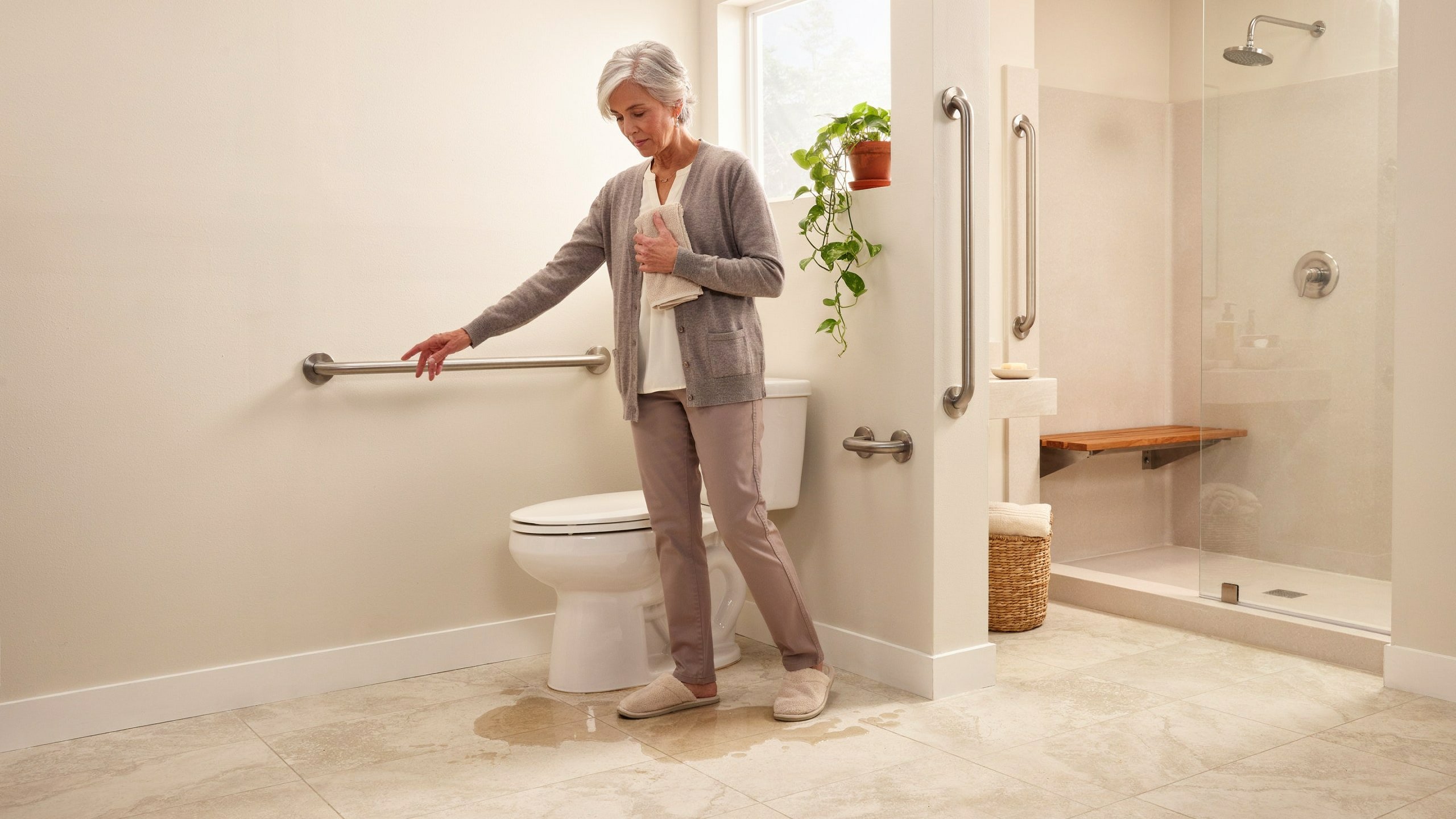 Bathroom Safety for Seniors With Grab Bars Older adult using a bathroom with grab bars beside a toilet and wet floor